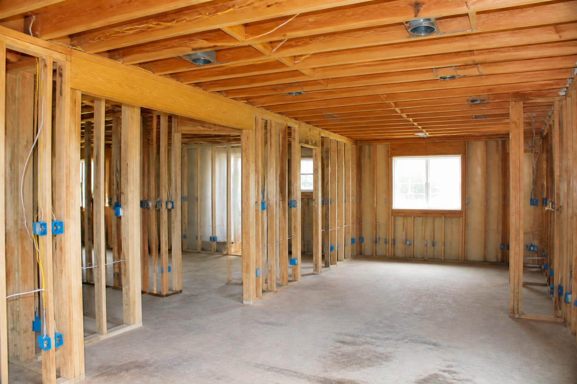 Residential remodel interior with exposed framing and electrical rough-in wiring and boxes